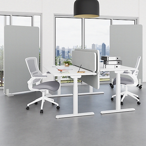 A modern office space with gray partitions, white desks, chairs and large windows with a city view.