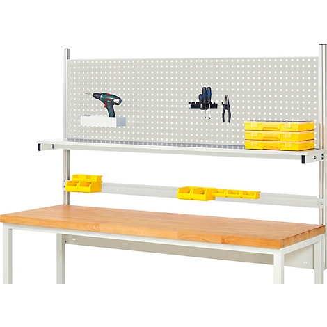 Werkbank mit Werkzeug und Zubehör. Auf der Rückwand sind Werkzeuge wie Bohrmaschine und Zangen befestigt. Auf der Ablage sind Werkzeugboxen.