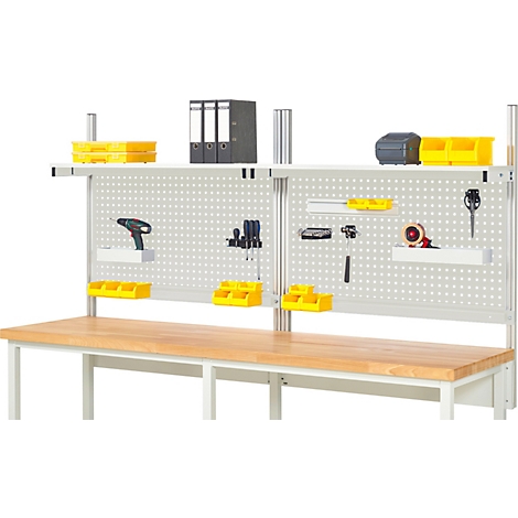 Werkbank mit Lochwand, Werkzeug und gelben Behältern.