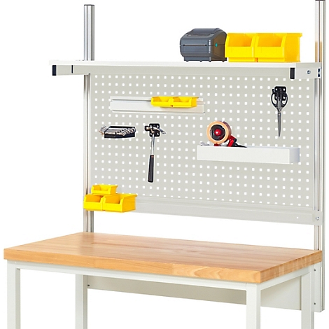 Établi avec outils et accessoires. Marteau, ciseaux, ruban adhésif et récipients jaunes sont fixés au panneau perforé. Dessus de table en bois.