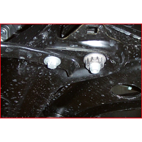 Nahaufnahme von zwei Schrauben, die an einem schwarzen Metallrahmen befestigt sind. Das Metall hat kleine Unebenheiten.