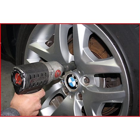 Eine Person schraubt mit einem Schlagschrauber an einem BMW-Rad.