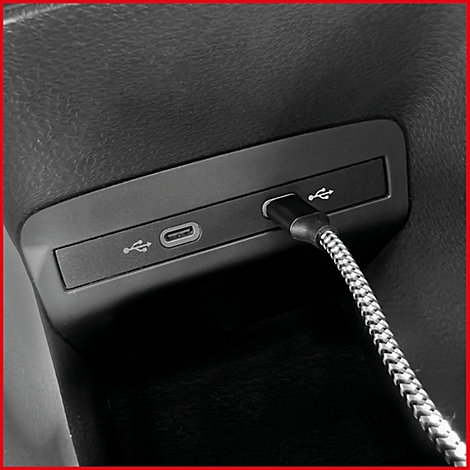 Nahaufnahme einer USB-Buchse im Auto, mit Kabel.