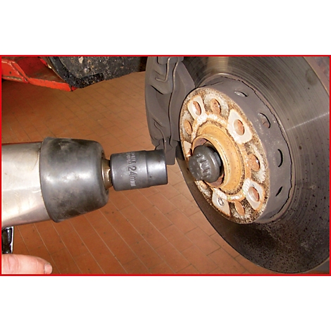 Ein Schraubenschlüssel wird an der Radnabe eines Autos verwendet, um die Radmutter zu lösen.