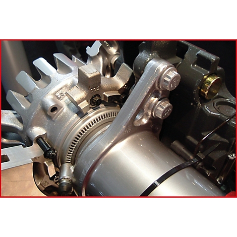 Nahaufnahme einer Metallkonstruktion mit Zahnrad und Schrauben. Die Detailaufnahme zeigt metallische Oberflächen und technische Elemente.