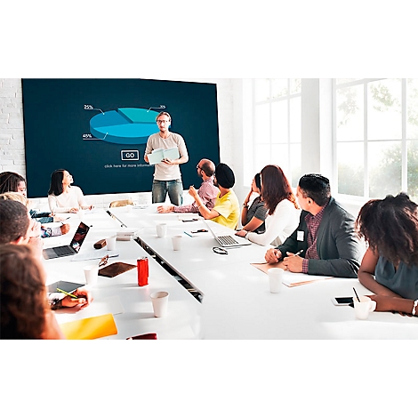 A man presents a graphic in a meeting. A group of colleagues sit at a table and listen.