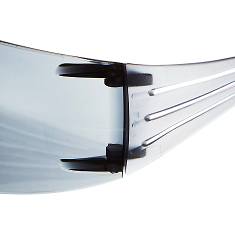 Detailaufnahme einer transparenten Schutzbrille, Fokus auf dem Nasenbereich und den Bügeln.