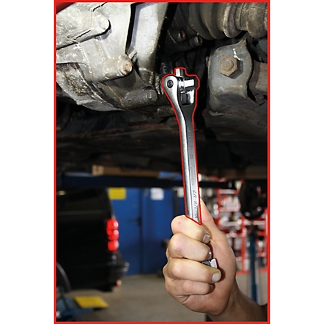 Ein Mechaniker schraubt mit einem Schraubenschlüssel an einem Fahrzeug. Der Schraubenschlüssel ist auf einen Bolzen unter dem Fahrzeug gerichtet.