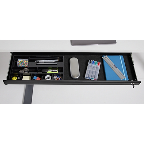 Bureau lade met schrijfgerei: pennen, notitieboek, liniaal, paperclips.