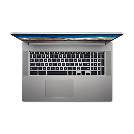 Draufsicht auf einen silberfarbenen Laptop, der geöffnet auf einem weißen Hintergrund liegt. Das Display zeigt eine Strandansicht. Tastenbeschriftung schwarz.