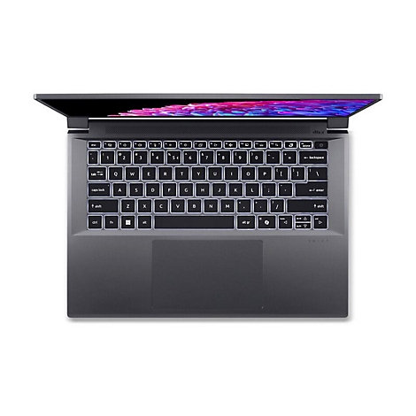 Draufsicht auf einen geöffneten Laptop mit leuchtender Tastatur. Der Bildschirm zeigt ein abstraktes Muster.