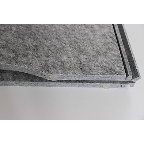 Close-up of grey felt. The corners are rounded, small transparent plastic feet underneath.