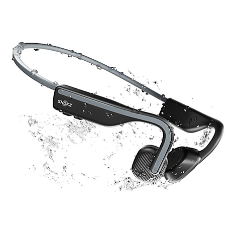 Schwarze Shokz-Knochenschallkopfhörer vor weißem Hintergrund mit spritzendem Wasser umgeben.