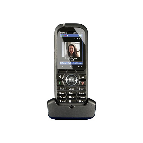 Schwarzes Telefon mit Ladeschale, Display zeigt Videoanruf. Frau lÃ¤chelt. Tastenfeld und Navigationstasten darunter.