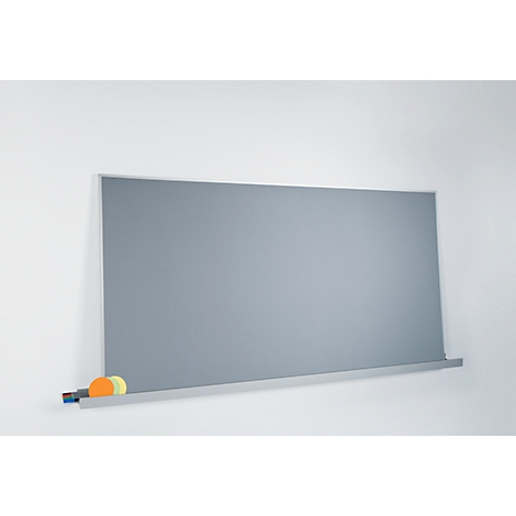 Graue Tafel mit Stiften und Schwämmen an weißer Wand.