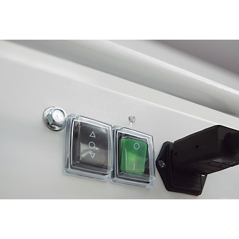 Close-up of two switches, a grey switch with arrow signs and a green switch, plus a black connector.