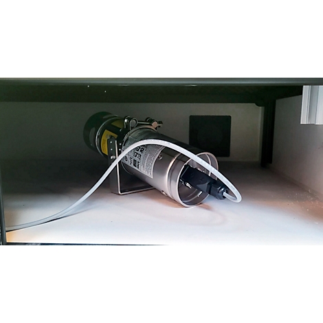 Zylinderförmiges Metallgerät in einem Schrank, befestigt mit Kabeln.