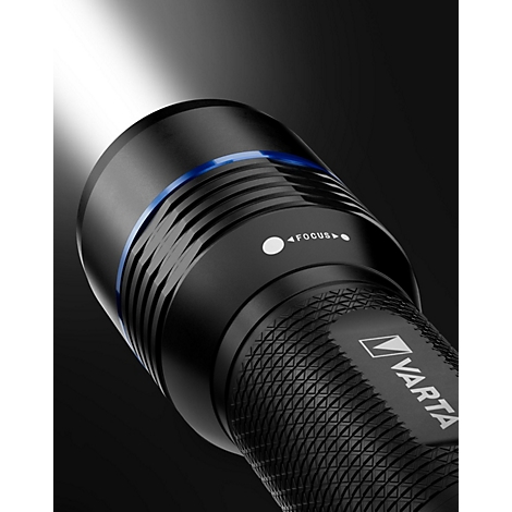 Nahaufnahme einer schwarzen Taschenlampe mit blauem Ring und der Aufschrift "Focus". Helles Licht nach oben gerichtet.