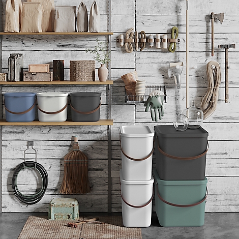 Tools and buckets in front of a rustic wooden wall. Various colors, materials and shapes.