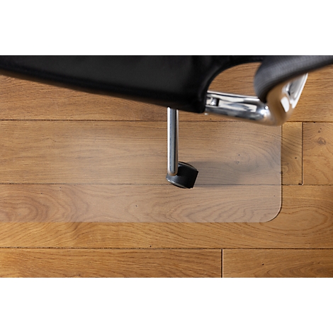 Silla de oficina sobre un protector de suelo transparente sobre un suelo de madera. La silla y la alfombra transparente son el centro de atención.