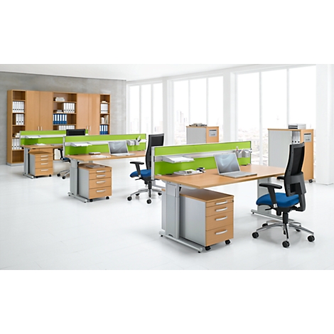 Office space with desks, chairs, filing cabinets, and green privacy screens. Bright environment, large windows.
