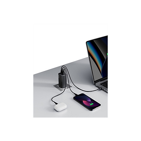Schwarzes Ladegerät, das Laptop, Handy und Kopfhörer mit Strom versorgt. Auf dem Handy wird "100% geladen" angezeigt.