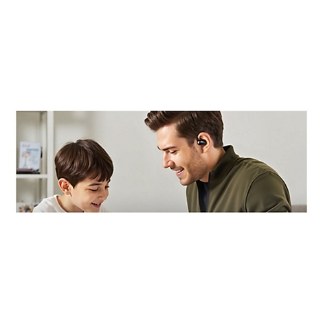Ein lächelnder Vater trägt einen schwarzen In-Ear-Kopfhörer und schaut liebevoll auf seinen lachenden Sohn.