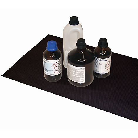 Four bottles stand on a black table: two brown bottles, a white one and one with a blue cap.