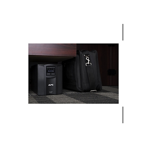 Onduleur noir sous une armoire, à côté d'un sac messager noir.