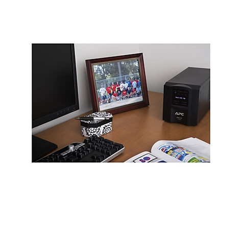 Schreibtisch mit Monitor, Foto, Stift, Schatulle, Tastatur, Zeitschrift und USV.