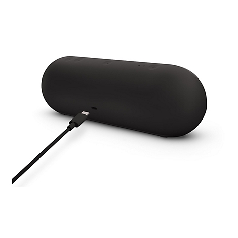 Haut-parleur noir avec câble de chargement. Les commandes sont situées sur le dessus. Câble USB-C connecté.
