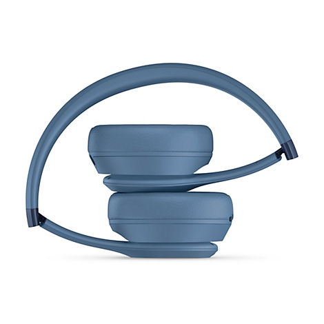 Casque bleu-gris, plié. Le support entoure les écouteurs. Fond blanc.