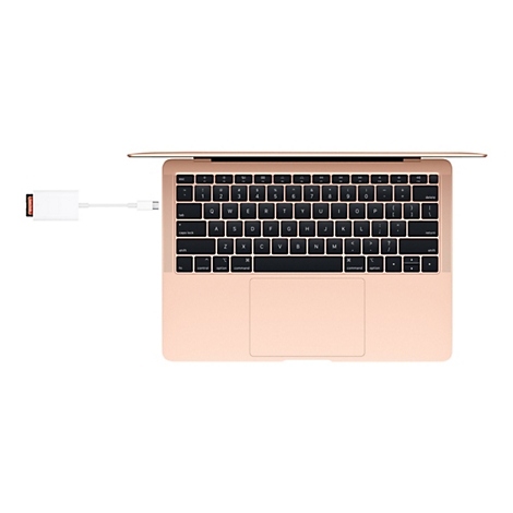 Vue de dessus d'un Macbook Air or rose avec adaptateur USB-C et carte SD connectés.