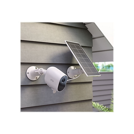 Weiße Überwachungskamera mit Solarpanel an grauer Hauswand. Das 'Arlo'-Logo ist sichtbar.