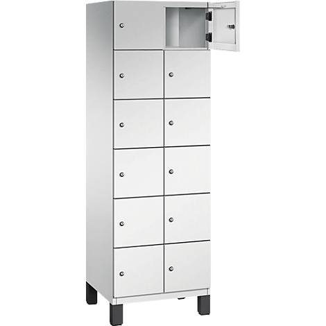 Armoire blanche et haute avec 10 portes, une porte ouverte, poignées métalliques. L'armoire repose sur des pieds noirs.