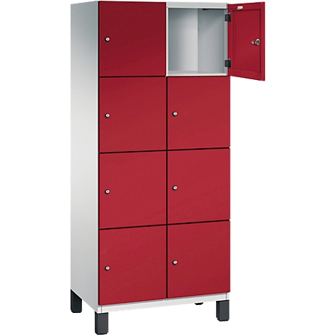 Armoire rouge à six portes, une porte ouverte, corps gris, repose sur des pieds noirs.
