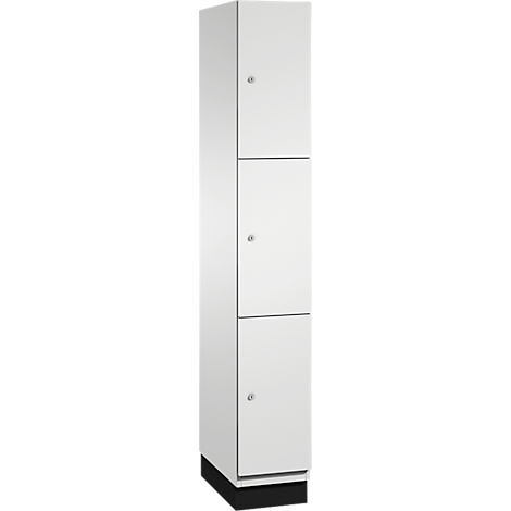 Armoire blanche avec trois portes et petits boutons. Moitié inférieure noire. Tient droit.