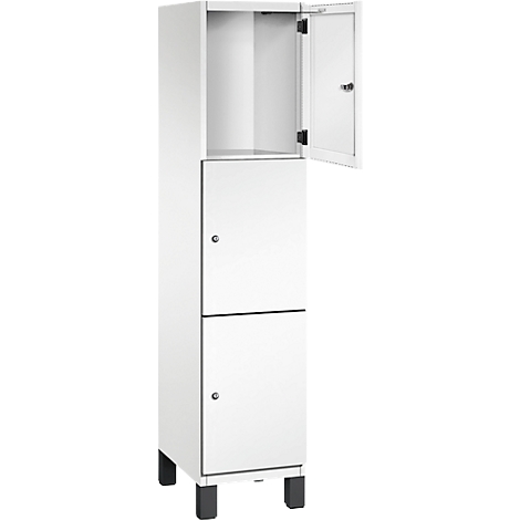 Armoire blanche à deux portes, dont une est ouverte. Pieds noirs.