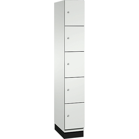 Haute armoire blanche avec cinq tiroirs et des boutons argentés. L'armoire est posée sur un socle noir.