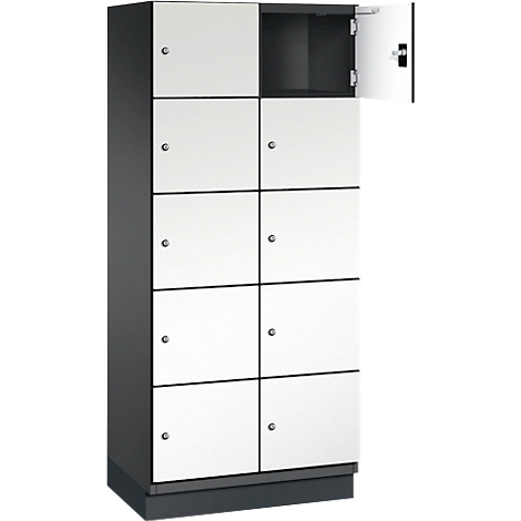 Armoire à portes blanches, une porte ouverte. Corps gris, intérieur sombre.