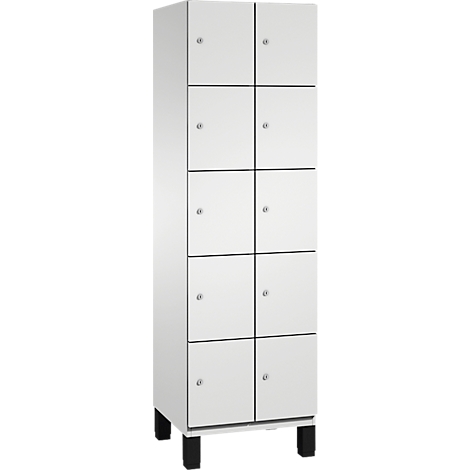 Une armoire blanche avec dix compartiments. Elle repose sur quatre pieds noirs. Chaque compartiment a une petite poignée ronde argentée.
