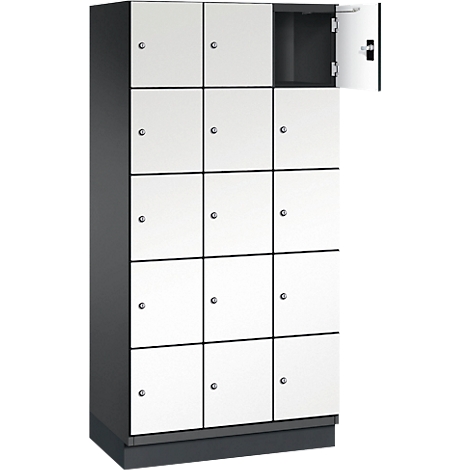 Armoire avec 15 portes blanches. Une porte est ouverte.