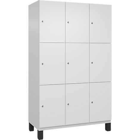 Armoire blanche avec neuf portes, chacune avec un petit bouton, repose sur des pieds noirs.