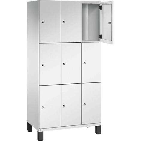Armoire blanche à huit portes. Une porte est ouverte. Pieds noirs. Casier.