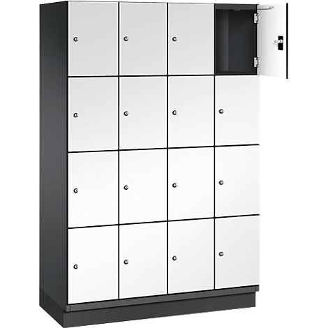 Une armoire avec 16 portes blanches, une porte est ouverte. Cadres noirs, poignées argentées.