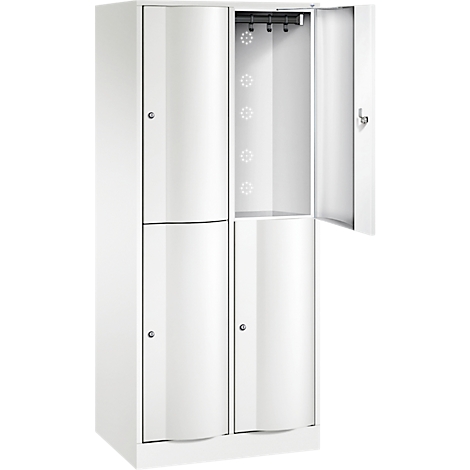Armoire blanche, portes partiellement ouvertes. On distingue des compartiments, une tringle à vêtements et des éléments décoratifs.
