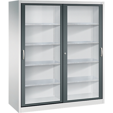 Armoire métallique grise avec deux portes coulissantes vitrées et quatre étagères sur fond blanc.