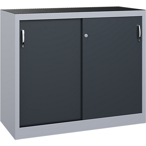 Une armoire basse en métal gris clair avec des portes coulissantes gris foncé et des poignées chromées sur fond neutre.