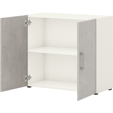 Armoire blanche, portes grises, ouverte. Deux étagères à l'intérieur, poignées métalliques sur les portes.