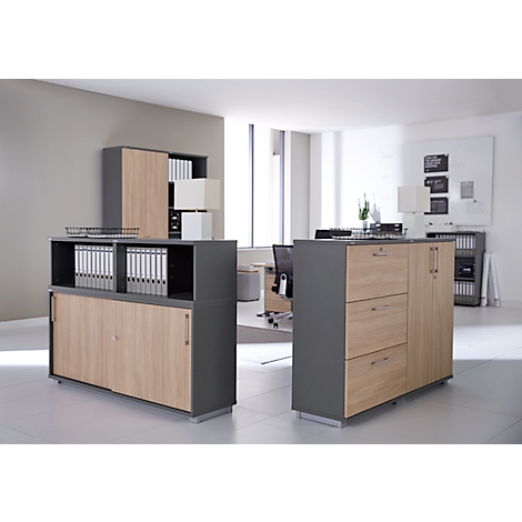 Vue de bureau avec deux armoires avec façades en bois et corps gris. Des chemises et des fournitures de bureau sont visibles.